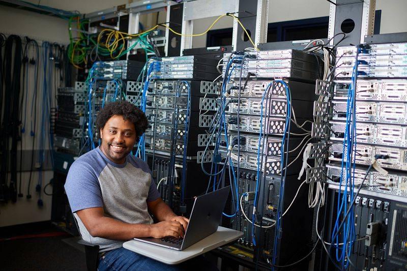 A GVSU graduate student working with computer equipment.